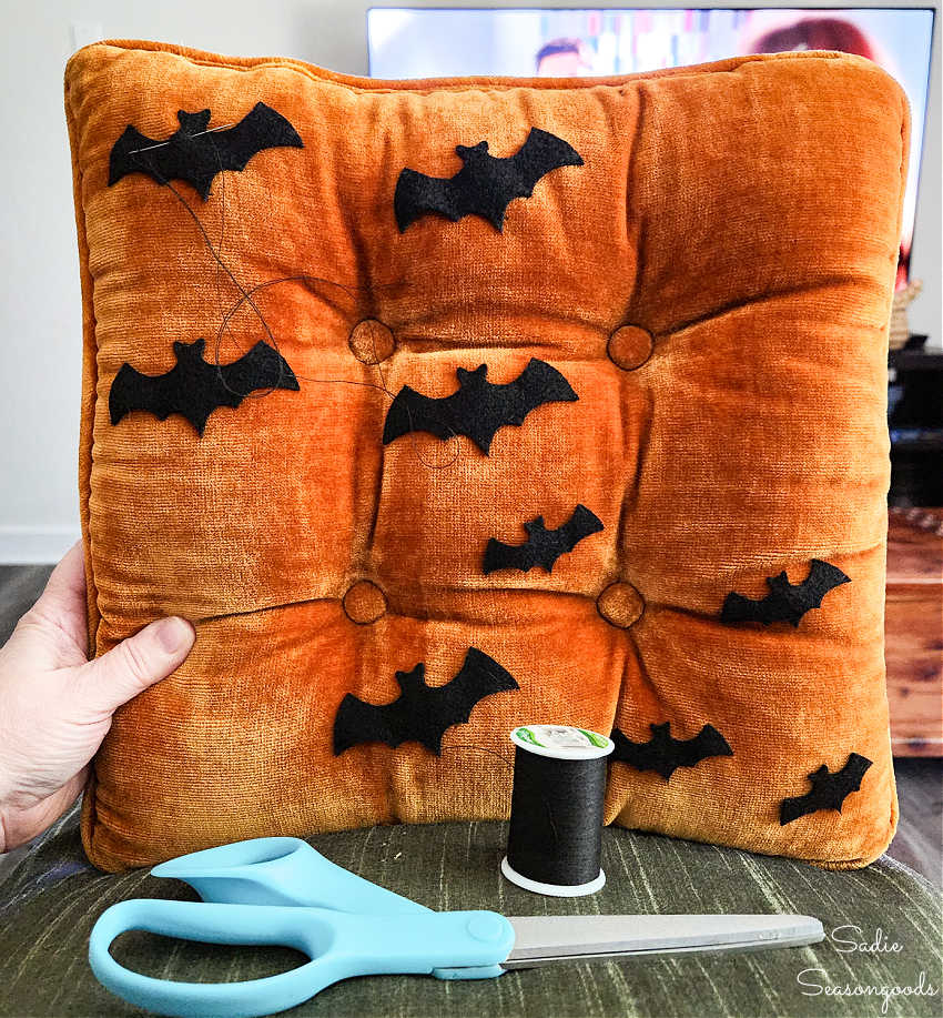 attaching felt bats to a halloween pillow