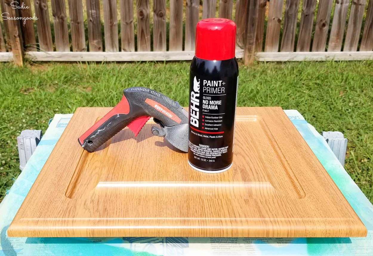 spray painting a cabinet door for christmas decor