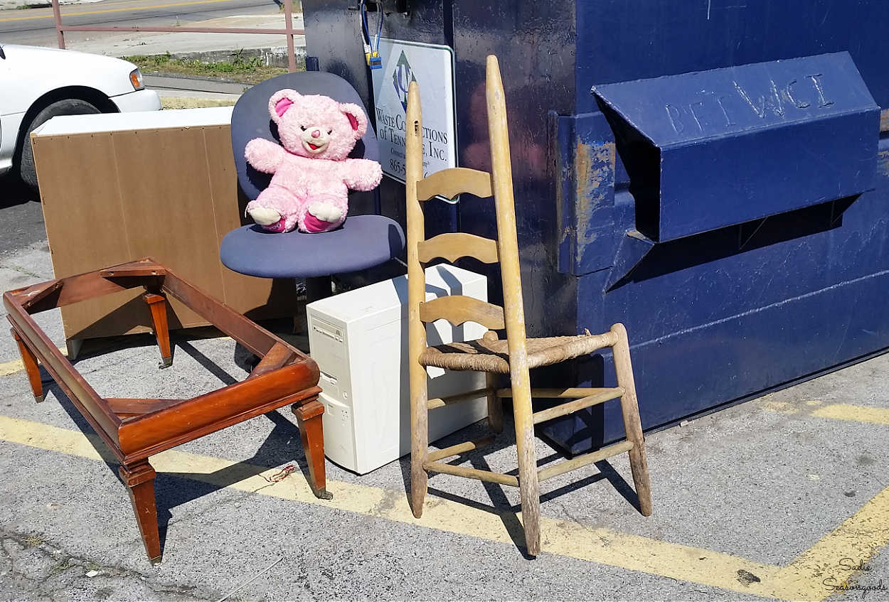 broken chair at a dumpster